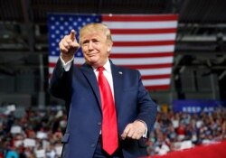 President Donald Trump gestures to the crowd as he arrives to speak at a campaign rally at Williams Arena in Greenville, N.C., July 17, 2019.