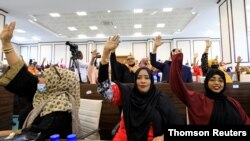 omali legislators of the lower house of parliament raise their hands to vote to extend President Mohamed Abdullahi Mohamed's term for another two years to let the country prepare for direct elections, in Mogadishu, Somalia, April 12, 2021.
