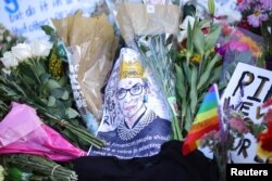 Flowers and tributes are seen as people gather in front of the U.S. Supreme Court following the death of U.S. Supreme Court Justice Ruth Bader Ginsburg, in Washington, Sept. 19, 2020.