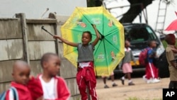 A child plays with an umbrella bearing the portrait of Zimbabwean President Emmerson Mnangagwa, at a public school in Harare, Feb. 5, 2019. Public teachers are alleging intimidation as they try to launch a nationwide strike for better salaries.