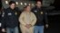 FILE - Mexico's top drug lord Joaquin "El Chapo" Guzman is escorted as he arrives at Long Island MacArthur airport in New York, Jan. 19, 2017, following his extradition from Mexico.