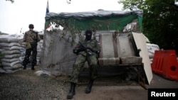 Pro-Russian fighters man a checkpoint in the eastern Ukrainian city of Donetsk, July 7, 2014.