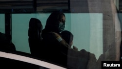 Afghan refugees sit in a bus taking them to a processing center upon arrival at Dulles International Airport in Dulles, Virginia, Aug. 28, 2021.