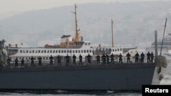 FILE - U.S. sailors stand aboard the USS Ross as it leaves from the port of Istanbul, Nov. 13, 2014.