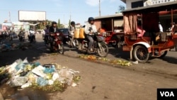 Piles of garbage, mostly plastic bags, are scattered on a road near Derm Kor Market, Phnom Penh, Cambodia, July 3, 2015. (Ouch Nida/VOA Khmer)