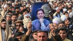 Seorang pendukung mantan PM Imran Khan yang dipenjara, memegang posternya selama pertemuan partai Pakistan Tehreek-e-Insaf (PTI) untuk memperingati "Hari Martir" guna menghormati mereka yang diduga tewas selama aksi protes bulan lalu, di Peshawar 15 Desember 2024. 