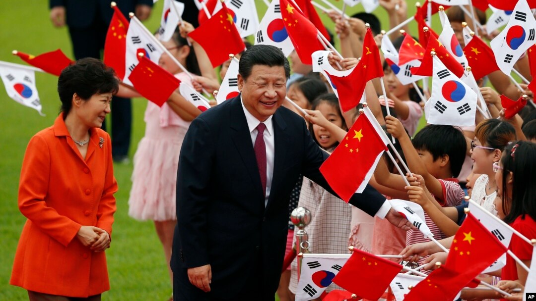 Chinese President Xi Jinping, right, and South Korean President Park Geun-hye, left, greet children at the Presidential Blue House in Seoul, South Korea, July 3, 2014.