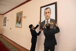 Afghan embassy staff hang a portrait of Afghan First Vice President Amrullah Saleh, who declared himself the "legitimate caretaker president", on the wall at the embassy in Dushanbe, Tajikistan, in this picture released August 18, 2021.