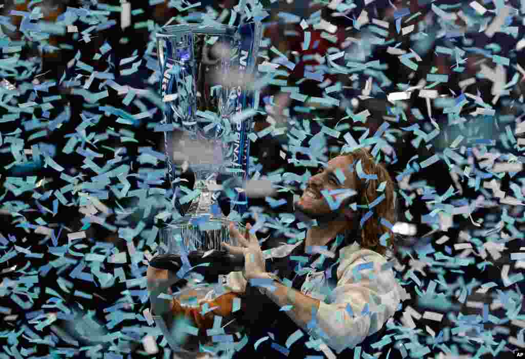 Stefanos Tsitsipas of Greece holds up a trophy and celebrates as confetti falls after defeating Austria&#39;s Dominic Thiem in the final of the ATP World Finals tennis match at the O2 arena in London, Nov. 17, 2019.