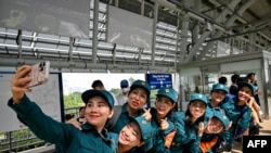 Sejumlah tentara mengambil selfie di stasiun metro di Kota Ho Chi Minh, Vietnam, pada 22 Desember 2024. (Foto: AFP/Nhac Nguyen)