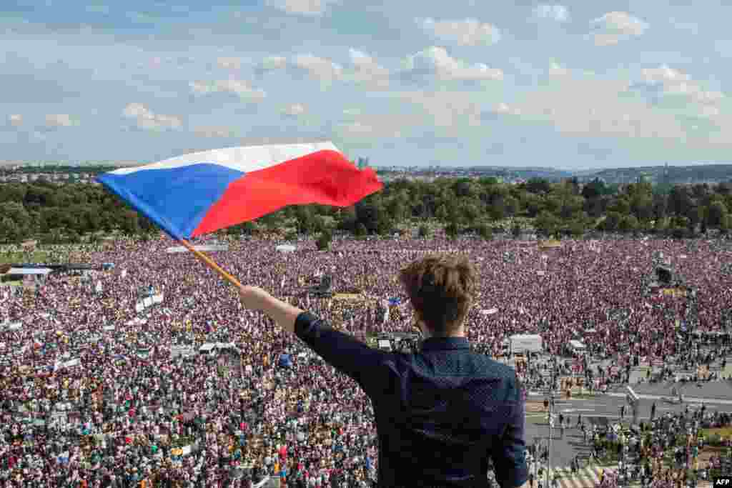 A man holds a Czech National flag during a rally demanding the resignation of Czech Prime Minister Andrej Babis in Prague.
