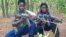FILE - Fighters loyal to the Lord's Resistance Army pose with their rifles inside the forest near River Mbou in the Central African Republic in this handout picture dated April 4, 2012.