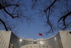 FILE - A Chinese national flag flies at the headquarters of the People's Bank of China, the country's central bank, in Beijing, China, Jan. 19, 2016.