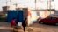 Workers ride a tricycle outside a construction site of a residential real estate project in Beijing, China, January 13, 2013.
