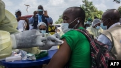 FILE - A health worker from the Guinean Ministry of Health administers an anti-Ebola vaccine in Gueckedou, Guinea, Feb. 23, 2021. 