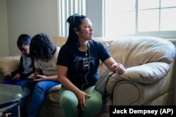 María Ángel Torres talks during an interview at her apartment as children play on their phones Friday, May 18, 2024, in Aurora, Colorado. (AP Photo/Jack Dempsey)