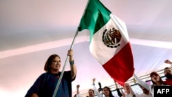 Kandidat presiden Meksiko dari kubu oposisi, Xochitl Galvez, mengibarkan bendera Meksiko dalam sebuah kampanye di Lagos de Moreno, negara bagian Jalisco, Meksiko, pada 11 Mei 2024. (Foto: AFP/Ulises Ruiz)