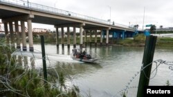 Petugas Patroli Perbatasan berpatroli di sungai Rio Grande, Eagle Pass, Texas, AS, saat kota-kota perbatasan AS bersiap menghadapi masuknya pencari suaka menjelang berakhirnya pembatasan migrasi "Title 42", 19 Desember 2022. (REUTERS/ Jordan Vonderhaar)