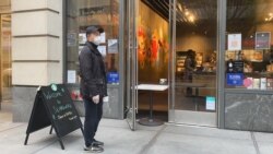 A man waits outside a Starbucks coffee shop at 34th street and 9th Ave. After weeks of not being open in this area, the coffee chain opened its doors with new social distancing measures. (Photo: Celia Mendoza / VOA)