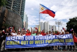 FILE - Filipino activists march to protest against the presence of Chinese vessels in disputed parts of the South China Sea, at the Chinese Embassy in Makati City, Philippines, April 9, 2019.