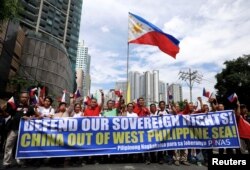 FILE - Filipino activists march to protest against the presence of Chinese vessels in disputed parts of the South China Sea, at the Chinese Embassy in Makati City, Philippines, April 9, 2019.