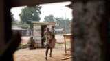 A woman runs for cover as heavy gunfire erupts in the Miskin district of Bangui, Central African Republic. In what a French soldier on the scene described as the heaviest exchange of fire he&#39;d seen since early December 2013, Muslim militias engaged Burundi troops who returned fire. 