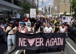 FILE - Protesters assembled by a majority Jewish group called Never Again Is Now walk through traffic as they make their way to Independence Mall in Philadelphia, July 4, 2019.