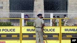 Policemen stand guard outside the Taj Mahal hotel in Mumbai. Multiple sites in the Indian city of Mumbai were attacked with bombs and gunfire in a coordinated terror attack that began on November 26, 2008, ( File)