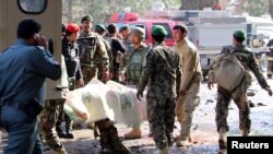 Prajurit Tentara Nasional Afghanistan (ANA) mengangkut seorang korban ke sebuah ambulan setelah terjadinya serangan bunuh diri (11/2). Lashkar Gah, Helmand, Afghanistan. (foto: REUTERS/Abdul Malik)