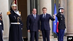 Presiden Mesir Abdel Fattah el-Sissi disambut oleh Presiden Prancis Emmanuel Macron untuk konferensi perdamaian tentang Libya di Istana Elysee di Paris, Jumat, 12 November 2021. (AP/Michel Euler)