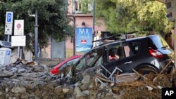 Broken cars are blocked in mud and debris in a street of Monterosso, one of the five villages that make up the Five Lands after overnight floods in the Spezia region, October 26, 2011