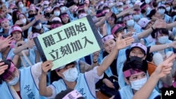 2019年6月21日一名台湾长荣航空公司的空服人员在罢工人群中手举“罢工开始立即加入”的标语牌。