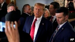 Former President Donald Trump greets supporters during a stop at the Front Street Pub & Eatery, Dec. 5, 2023, in Davenport, Iowa.