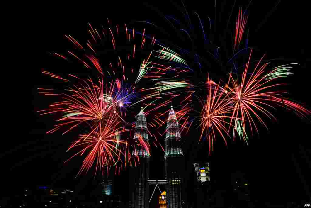 Fireworks explode near Malaysia&#39;s landmark Petronas Twin Towers in Kuala Lumpur during the New Year 2014 celebrations.