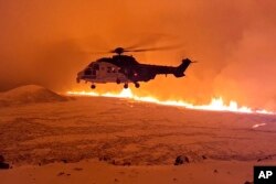 Helikopter obalske straže leti iznad magme oslobođene erupcijom vulkana nedaleko od Grindavika, Island, 19. decembra 2023.