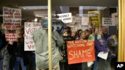 Protesters gather outside a press conference room during a special session at the North Carolina Legislature in Raleigh, N.C., Dec. 15, 2016. Republicans called their own special session to weigh legislation, some of which threatens the incoming Democratic governor. 