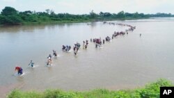 Migrantes salvadoreños cruzan el río Suchiate, en la frontera entre Guatemala y México, el viernes 2 de noviembre de 2018.