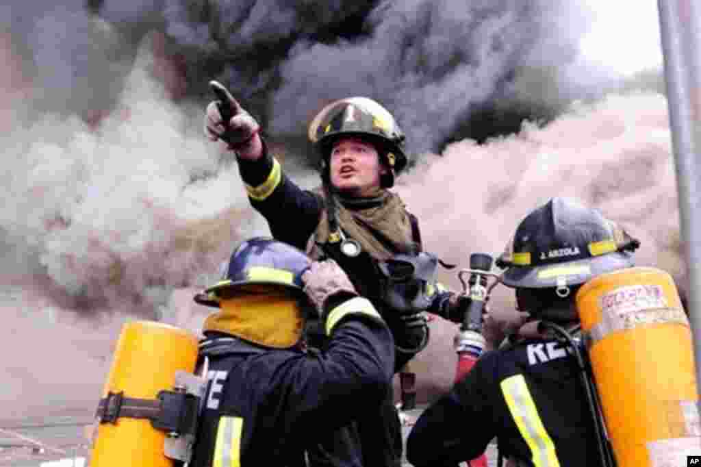 Firemen fight a fire in a supermarket in Concepcion, 01 Mar 2010
