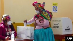 A women wearing traditional quechua attire casts her vote at a polling station in the rural Andean community of Capachica, Peru, June 6, 2021. 