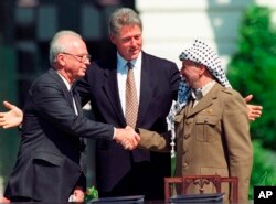 FILE - Israeli Prime Minister Yitzhak Rabin, left, and Palestinian leader Yasser Arafat shake hands marking the signing of the peace accord between Israel and the Palestinians, in Washington, Sept. 13, 1993.