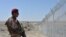A Pakistani army soldier stands guard along with border fence at the Pakistan-Afghanistan border near the Punjpai area of Quetta in Balochistan on May 8, 2018.