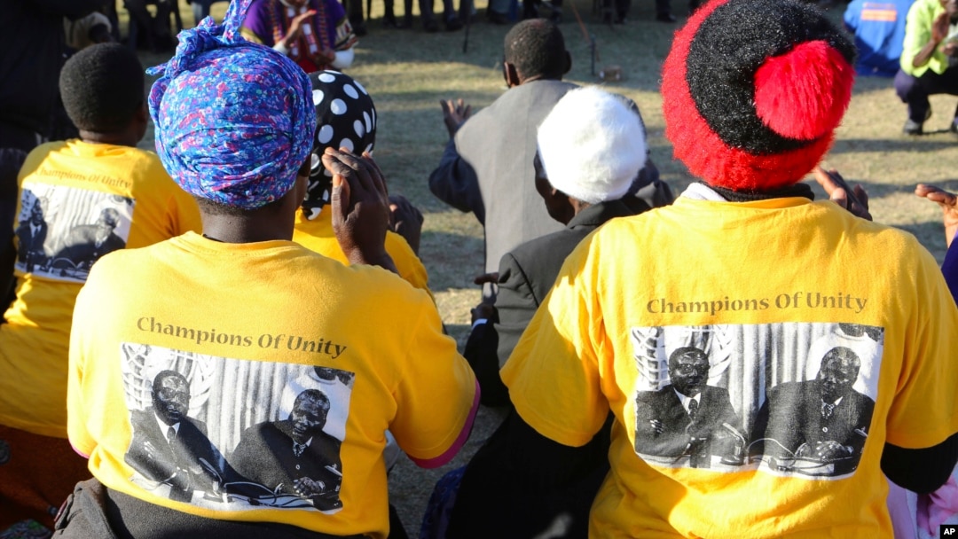 Supporters wearing t-shirts with a photo of former President Robert Mugabe, left,, at an election rally in Masvingo, Zimbabwe, July 14, 2018. 