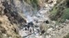Petugas keamanan memeriksa puing-puing kendaraan yang membawa warga negara China yang jatuh ke jurang di pegunungan Jalan Raya Karakoram akibat serangan bunuh diri di dekat kota Besham di distrik Shangla, provinsi Khyber Pakhtunkhwa, 26 Maret 2024. (AFP)