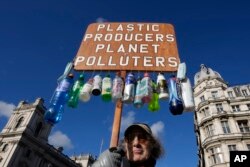 FILE —Anti plastics campaigner Robert Unbranded, who has been regularly clearing plastic waste from parks and streets in his local area of Redbridge, demonstrates in Westminster in London on Nov. 2, 2021.