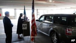 In this June 26, 2020 photo, U.S. District Judge Laurie Michelson, center, administers the Oath of Citizenship during a drive-thru naturalization service in a parking structure at the U.S. Citizenship and Immigration Services headquarters in Detroit.