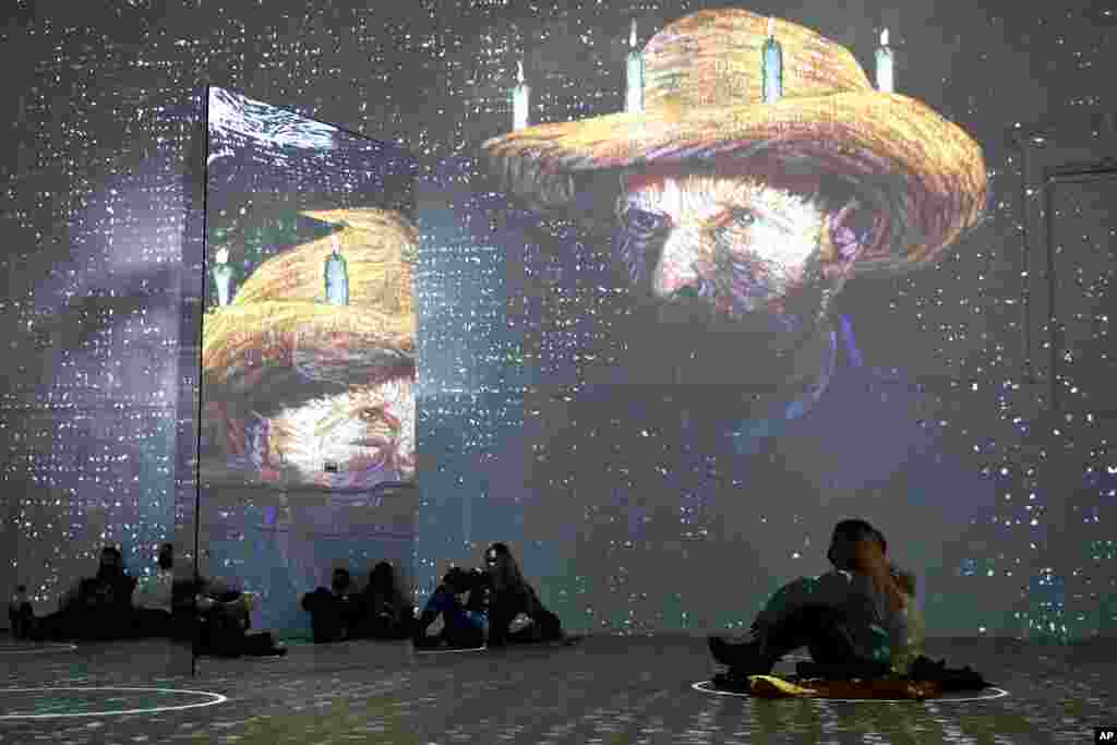 Patrons look at images cast on the wall and reflected in mirrors during a virtual display titled &quot;Immersive Van Gogh&quot; at the Lighthouse ArtSpace, in Chicago, Feb. 18, 2021.