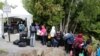 A line of asylum-seekers who said they were from Haiti wait to enter into Canada from Roxham Road in Champlain, New York, Aug. 7, 2017.