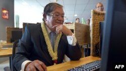 FILE - Cambodian Information Minister Khieu Kanharith looks at a monitor during the Inauguration of Radio France Internationale in Phnom Penh, June 20, 2013. 