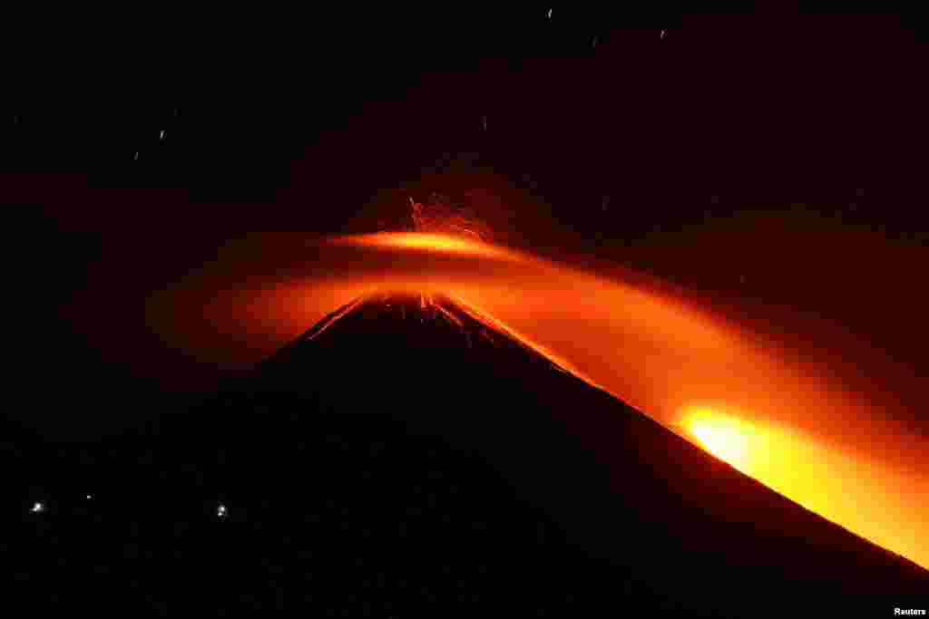 Streams of red hot lava shoot into the night sky during an eruption of the Pacaya volcano, as seen from Los Rios, Guatemala, March 3, 2021.