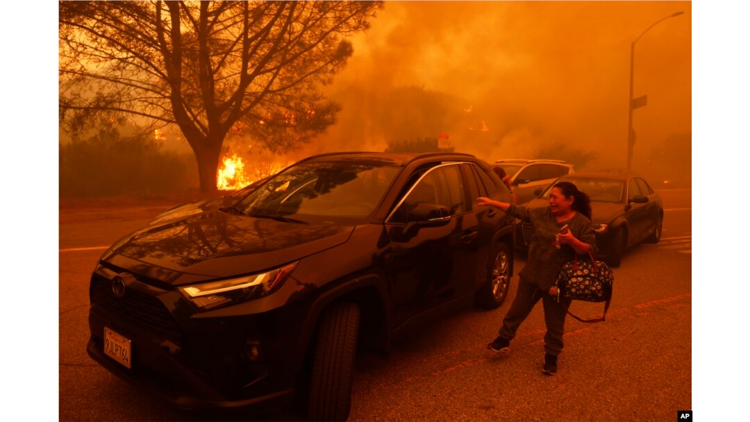 Žena plače dok bjesni požar u četvrti Pacific Palisades u Los Angelesu, utorak, 7. januara 2025. (AP Photo/Etienne Laurent)